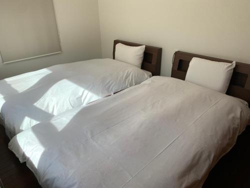 two beds sitting next to each other in a bedroom at Luxury ocean front house Bay-villa in Matsushima