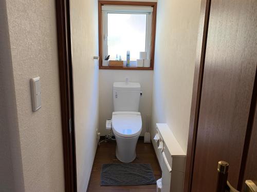 a small bathroom with a toilet and a window at Luxury ocean front house Bay-villa in Matsushima