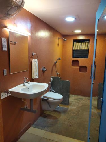 a bathroom with a sink and a toilet at Paradise Vana Vilasa Homestay with Swimming pool in Auroville