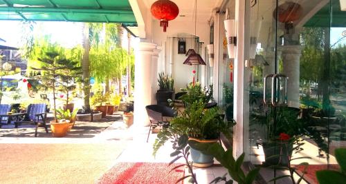 a patio with potted plants on the side of a building at ENE Inn in Kota Bharu