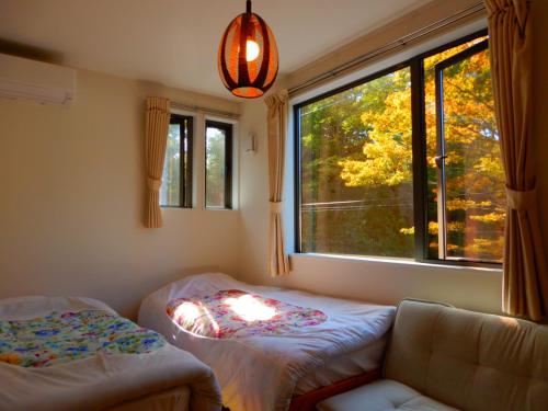 松島町にあるUchi 松島ゲストハウス　のベッド2台と大きな窓が備わる客室です。