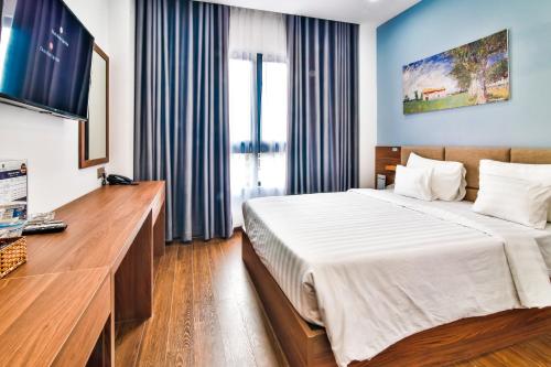 um quarto de hotel com uma cama e uma televisão em Grand Lee Hotel em Ho Chi Minh