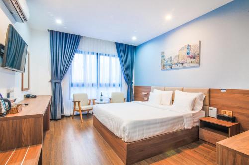 Habitación de hotel con cama y escritorio en Grand Lee Hotel, en Ho Chi Minh