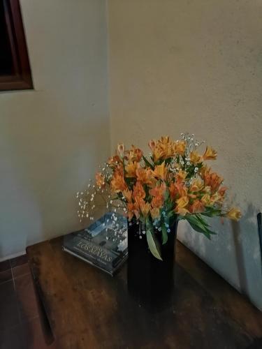 a black vase with orange flowers on a table at Posada Las Reynas in Mineral de Pozos