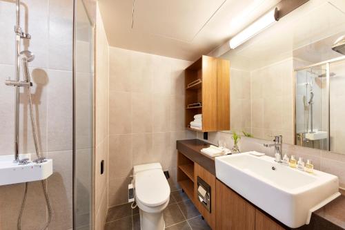 a bathroom with a sink and a toilet and a shower at Ramada by Wyndham Gumi in Gumi