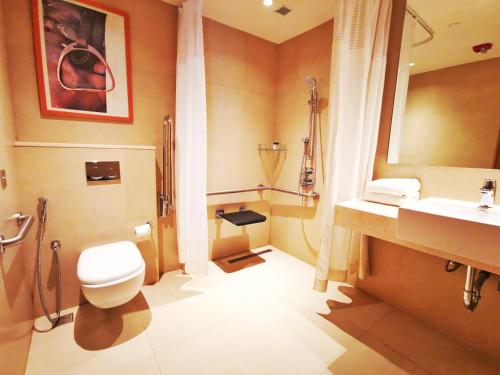uma casa de banho com um WC, um lavatório e um chuveiro em Holiday Inn Bengaluru Racecourse, an IHG Hotel em Bangalore