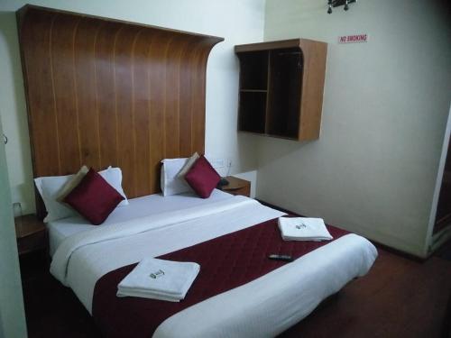 a hotel room with two beds with red and white towels at Red Star Holidays in Munnar