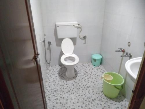 a bathroom with a toilet and a sink and a bucket at Red Star Holidays in Munnar