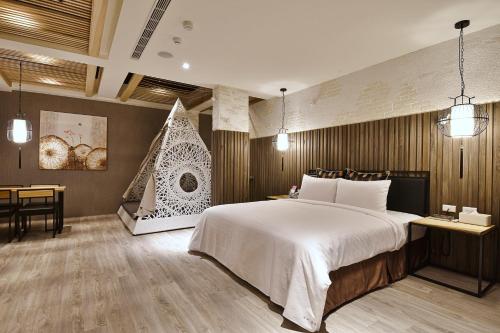 1 dormitorio con 1 cama grande, mesa y silla en 歐閣精品汽車旅館-簡愛館, en Kaohsiung