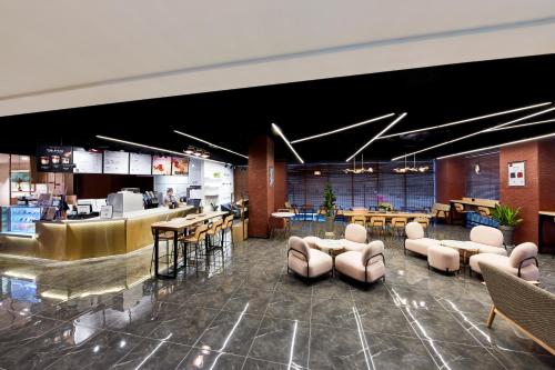 a lobby with chairs and tables and a bar at Ramada by Wyndham Gumi in Gumi