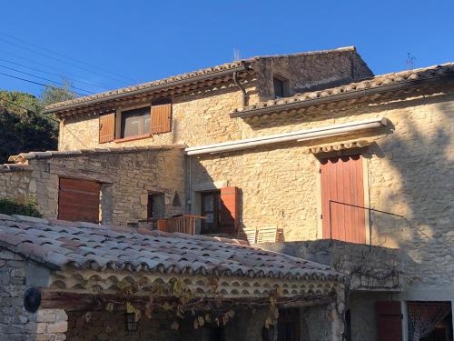 an old stone building with a red door on it at Le Mas de Fanny in Faucon