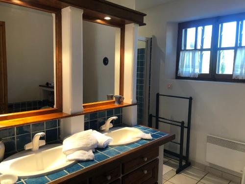 Le Mas de Fanny في Faucon: حمام مع حوض ومرآة كبيرة