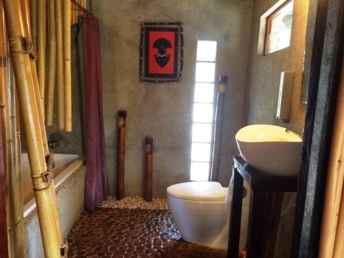 a bathroom with a toilet and a sink at The Village House in Puerto Princesa City