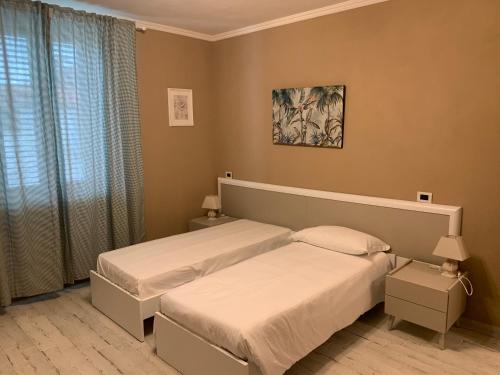 a bedroom with two beds and a window at Locanda il Deserto in Livorno