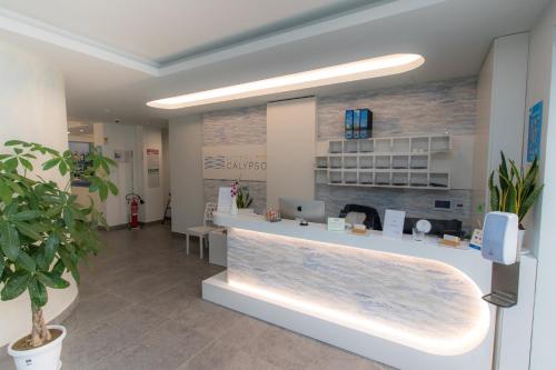 un hall d'un bureau de dermatologues avec un comptoir de réception dans l'établissement Hotel Calypso, à Pontecagnano