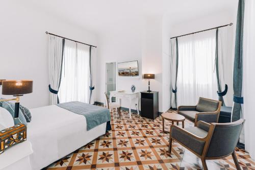 ein Hotelzimmer mit einem Bett und einem Stuhl in der Unterkunft Amalfi Luxury House in Amalfi