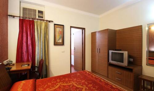 une chambre d'hôtel avec un lit et une télévision dans l'établissement Nu Delhi Homestay, à New Delhi