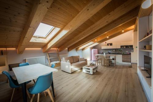 ein großes Wohnzimmer mit einem Tisch und Stühlen in der Unterkunft Loft 29 mansardato con ampio terrazzo in Bussoleno