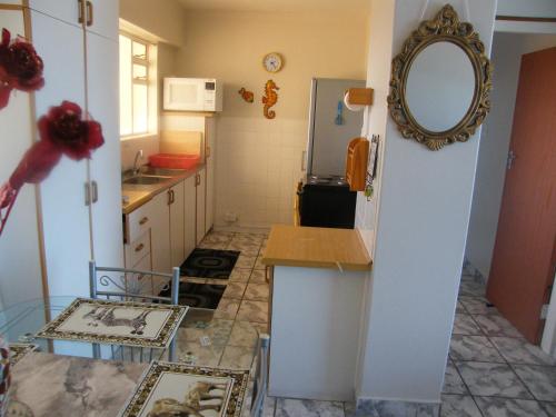 a kitchen with a sink and a mirror on the wall at 1102 High Tide Amanzimtoti in Amanzimtoti