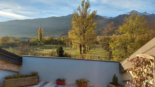 a balcony with a view of a field and mountains at Loft 29 mansardato con ampio terrazzo in Bussoleno