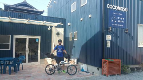 a man standing next to a bike in front of a building at Tiz wan 岩屋あわじ in Awaji