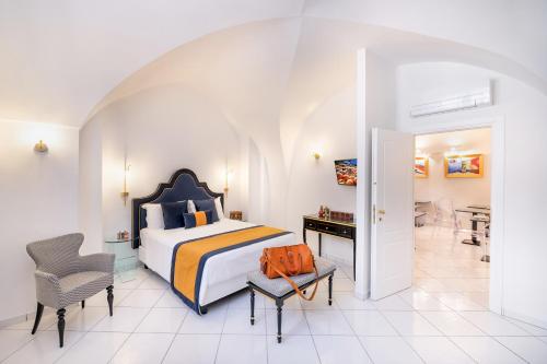 a bedroom with a bed and a desk and a chair at Amalfi Resort in Amalfi