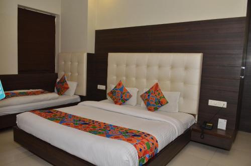 ein Schlafzimmer mit einem großen Bett mit einem großen Kopfteil in der Unterkunft Hotel KK Continental 50 Meter from Railway Station - Amritsar in Amritsar
