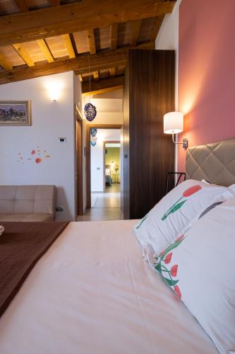 a bedroom with a large white bed and a hallway at B&B da Vi.Vì in Urbania