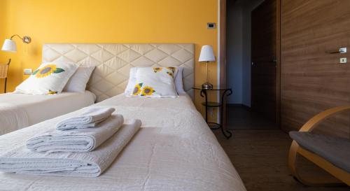 a bedroom with two beds with towels on them at B&B da Vi.Vì in Urbania