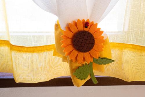 a sunflower on the curtain of a window at B&B da Vi.Vì in Urbania