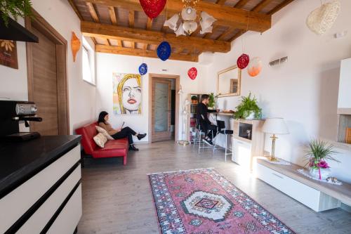 a woman sitting in a red chair in a living room at B&B da Vi.Vì in Urbania