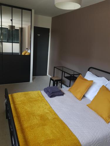 a bedroom with a large bed with yellow pillows at Escapade Amiens in Amiens