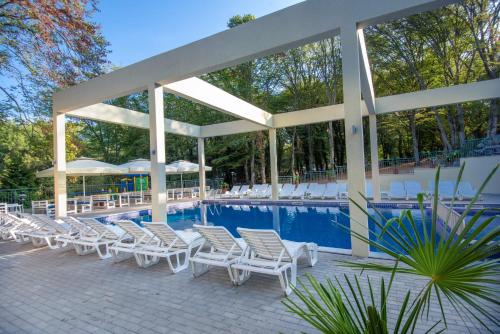 un grupo de sillas y una piscina en Ariana Hotel, en Kiten