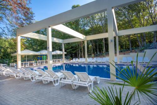 a group of chairs and a swimming pool at Ariana Hotel in Kiten