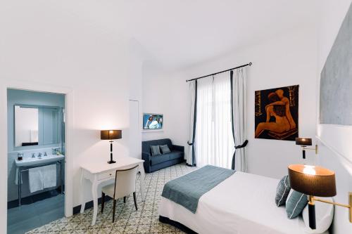 a hotel room with a bed and a table and a desk at Amalfi Luxury House in Amalfi