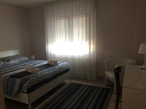 um quarto com uma cama e uma janela com luz solar em B&B Agli ulivi em Gemona del Friuli