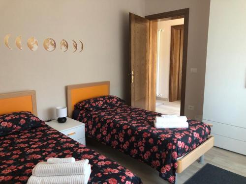 um quarto de hotel com duas camas e um espelho em B&B Agli ulivi em Gemona del Friuli