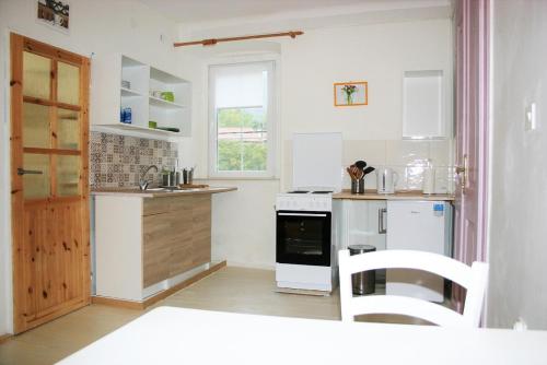 a white kitchen with a stove and a sink at Nerezine apartmany CENTRUM in Nerezine