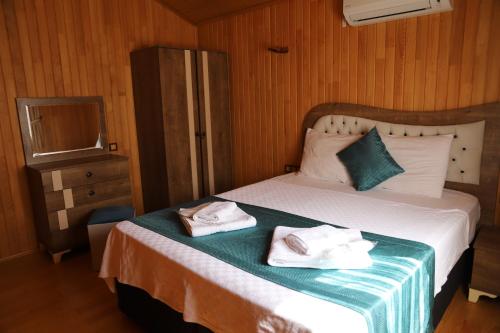 a bedroom with a bed with two towels on it at Leontopolis Apart Otel in Cıralı