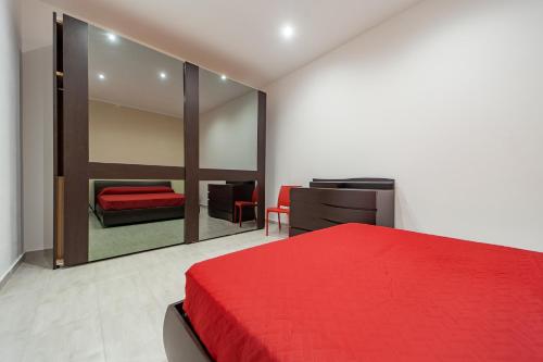 1 dormitorio con cama roja y espejo en Naranji House Red Relax, en Altavilla Milicia