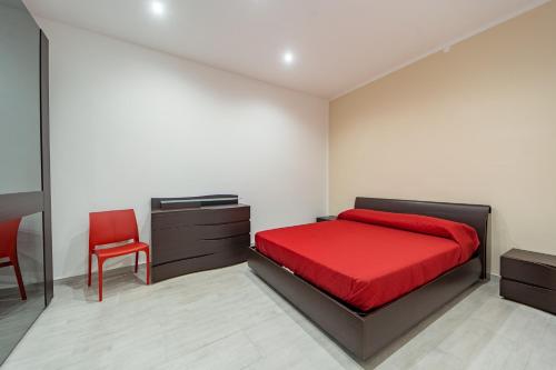 ein Schlafzimmer mit einem roten Bett und einem roten Stuhl in der Unterkunft Naranji House Red Relax in Altavilla Milicia