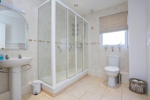 uma casa de banho com um chuveiro, um WC e um lavatório. em 6 Beech Court em Dunblane