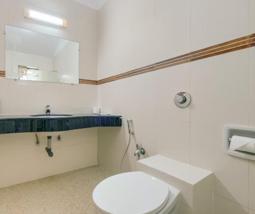 a bathroom with a white toilet and a sink at Spazio Leisure Resort, Goa in Anjuna