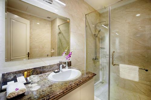 a bathroom with a sink and a shower at Riverside Hotel Quang Binh in Dong Hoi