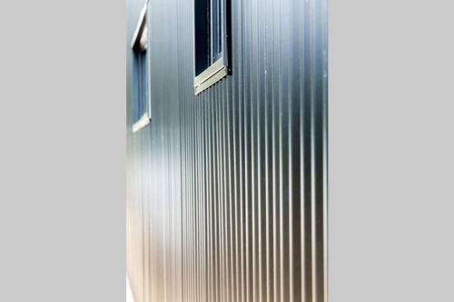 a metal building with two windows on the side of it at 3BlackSHEDS in Whitfield