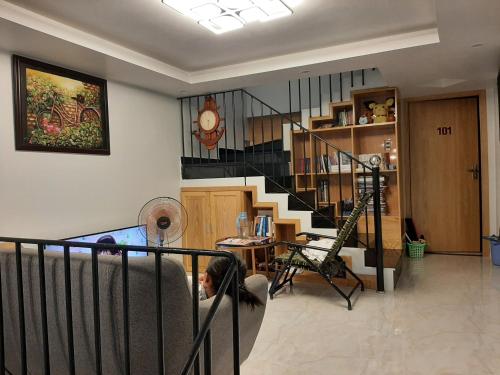 a living room with a staircase and a person laying on a couch at Thom's Homestay in Vung Tau