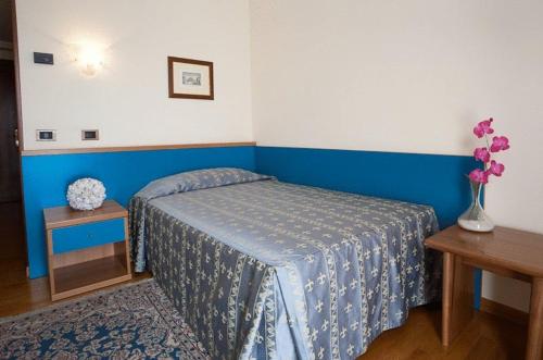 a bedroom with a bed and a vase with flowers at Hotel Spresiano in Spresiano