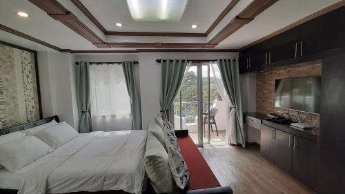 een slaapkamer met een bed en een groot raam bij Gab's CozyHome at Bonbel Condo, Botanical Gardens Baguio in Baguio