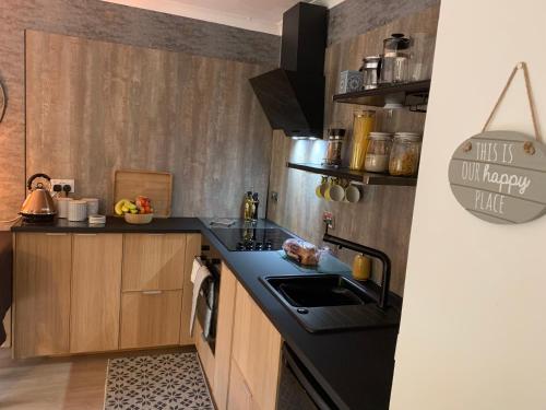 a kitchen with a black counter top and a sink at Aaron's Bothy in Portree