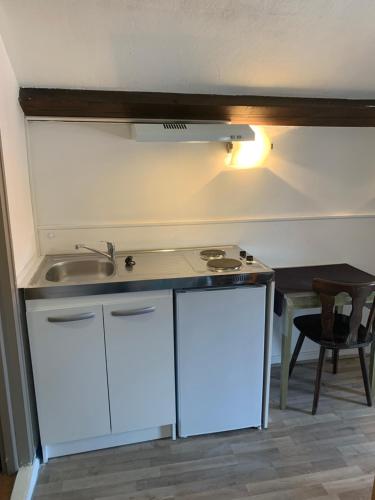 a kitchen with a sink and a counter top at hôtel Le Cosy in Pont-de-Chéruy